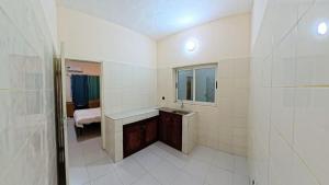 a white bathroom with a sink and a mirror at Captain Purunchi in Cotonou +22 photos