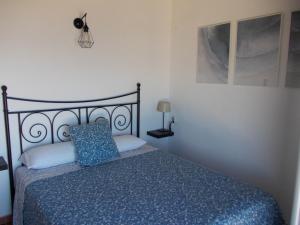 a bedroom with a bed with a blue comforter at Tabarca - El rincón de la Muralla in Tabarca