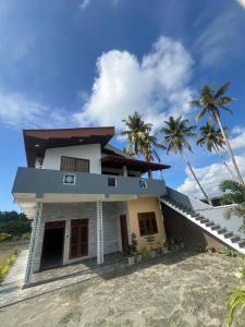 a house on the beach with palm trees at Apollo Villa Weligama in Weligama