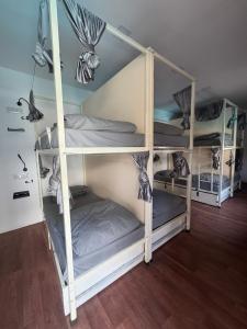 two bunk beds in a room with wooden floors at Simple Belle Stay ,Pool &Bar in Vagator