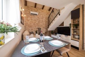 a dining room with a table with plates and wine glasses at Hidden Oasis - pool, playground - 3 min from the beach in Vir