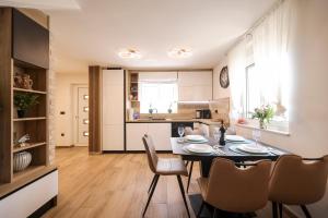 a dining room and kitchen with a table and chairs at Hidden Oasis - pool, playground - 3 min from the beach in Vir