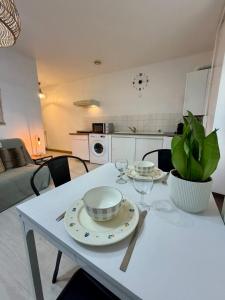 a white table with two plates and wine glasses on it at Jasmin in Bourg-lès-Valence
