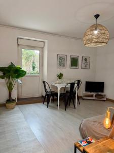 a living room with a table and chairs and a television at Jasmin in Bourg-lès-Valence +2 photos