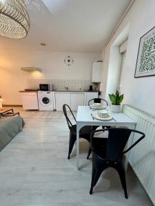 a kitchen and living room with a table and chairs at Jasmin in Bourg-lès-Valence
