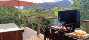 a grill on a deck with a view of a mountain at Chalé Vertente da Canastra in São Roque de Minas