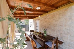 a dining room with a table and a stone wall at Hidden Oasis - pool, playground - 3 min from the beach in Vir