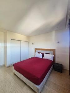 a bedroom with a large bed with a red blanket at Villa in Aït Bou Zguia