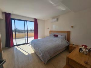 a bedroom with a bed and a large window at Villa in Aït Bou Zguia