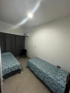 a bedroom with two beds and a chair in it at Linda Goya in Goya