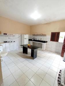 a large kitchen with a black table in it at Casa com piscina em Aldeia in Camaragibe +5 photos
