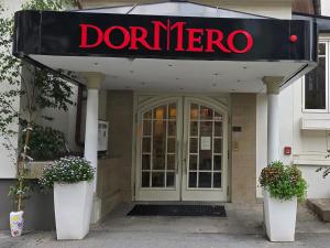 a front door of a donneragencyartment with a sign above it at DORMERO Hotel Coburg in Coburg