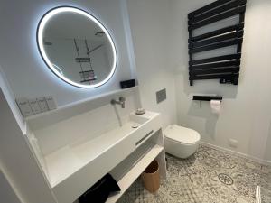 a white bathroom with a mirror and a toilet at Aplusstudio in Zottegem