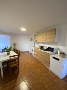 a kitchen with a table and a white refrigerator at Casa Rodrigues in Terras de Bouro