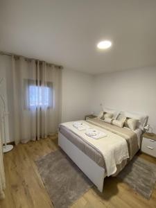 a white bedroom with a large bed in a room at Casa Rodrigues in Terras de Bouro