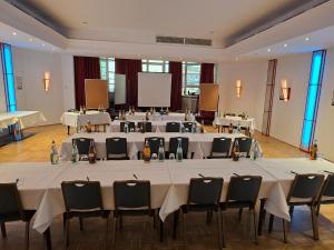 a large room with tables and chairs in it at DORMERO Hotel Coburg in Coburg