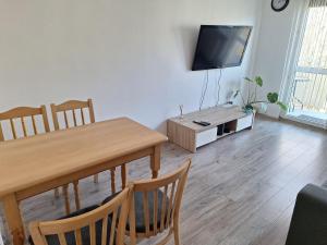 a living room with a dining room table and a flat screen tv at Mała dziupla in Opole +1 photo