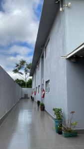 a hallway of a building with potted plants on it at Itu Loft Pousada Girassol in Itu