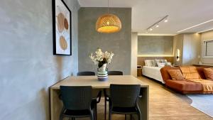 a living room with a table with chairs and a bed at Studio Red 12 - Sorocaba in Sorocaba