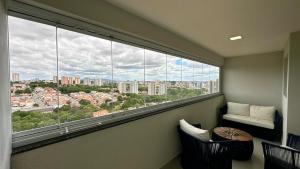 a room with a large window with a table and chairs at Studio Red 12 - Sorocaba in Sorocaba