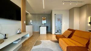 a living room with a couch and a tv at Studio Red 12 - Sorocaba in Sorocaba