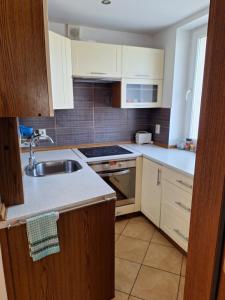 a kitchen with white cabinets and a sink at Mała dziupla in Opole