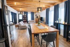 a dining room and living room with a wooden table and chairs at Le Cube in Drummondville