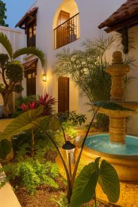 a garden with a fountain in front of a building at DezMont Guest House in Mérida