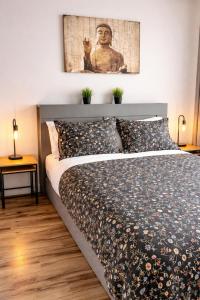 a bedroom with a large bed with a picture on the wall at Le Cube in Drummondville