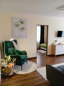 a living room with a green chair and a bedroom at Апартаменти GREEN центр вулиця Руська in Ternopil