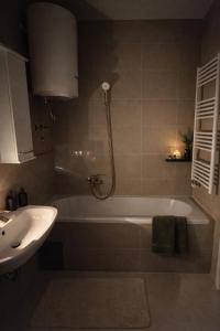 a bathroom with a bath tub and a sink at Avenoir Suite in Banja Luka +15 photos