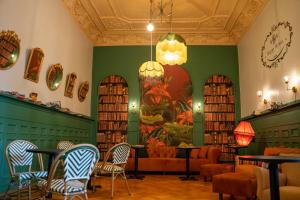 a library with chairs and tables and a couch at Happy House Hostel in Santiago
