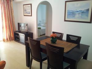 comedor con mesa, sillas y espejo en Frontbeach apartment in los Boliches, en Fuengirola