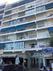 un gran edificio con balcones y un coche aparcado frente a él en Frontbeach apartment in los Boliches, en Fuengirola