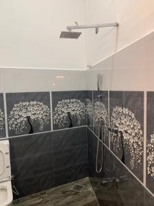 a bathroom with a shower with a glass wall at Nomin Villa in Kottagoda