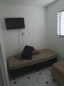 a bedroom with a bed with a tv on the wall at Itu Loft Pousada Girassol in Itu
