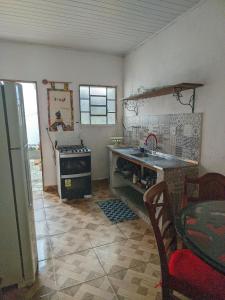a kitchen with a sink and a stove and a table at Belvedere das Estrelas in Lençóis +8 photos