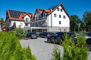 a parking lot with cars parked in front of a building at Ruchome Piaski in Łeba