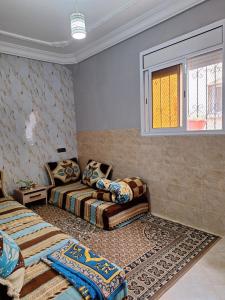 a living room with two beds and a window at Nawal's guest house in Tadouart