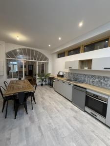 a kitchen with a table and a dining room at Les remparts in Chabeuil