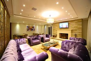 a living room with purple couches and a fireplace at Pousada Italia Eleganza in Campos do Jordão