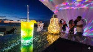 a drink sitting on a table with people at a party at Aparthotel Dalmacija in Privlaka