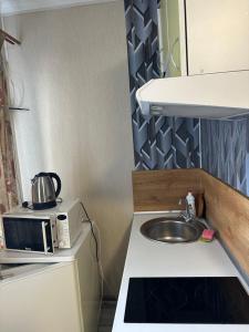 a small kitchen with a sink and a microwave at Апартамент студия in Khmelnytskyi