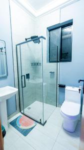 a bathroom with a glass shower and a toilet at K&K Luxurious Landing in Limbe +54 photos