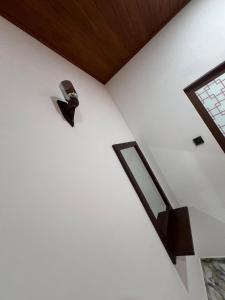 a white wall with a clock on the side of a room at Apollo Villa Weligama in Weligama