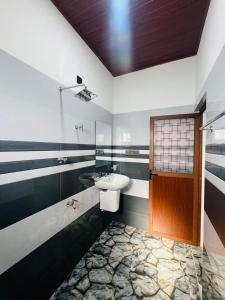 a bathroom with a sink and a toilet and a door at Apollo Villa Weligama in Weligama +46 photos