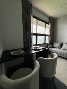 a living room with a table and two chairs at Flat Praia da Graciosa in Palmas +25 photos