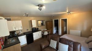 a kitchen and living room with a couch and a table at Kendall Lodge in Burwell +6 photos