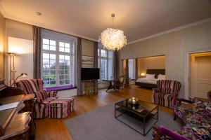 a living room with a couch and a bed at Hotel Schloss Wilkinghege in Münster