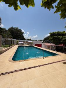 a large swimming pool with a tile floor at Brisas de melgar in Melgar +5 photos
